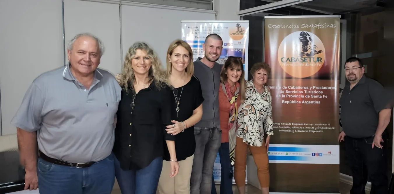 Integrantes de la comisión directiva de CABASETUR junto a los banners de la cámara