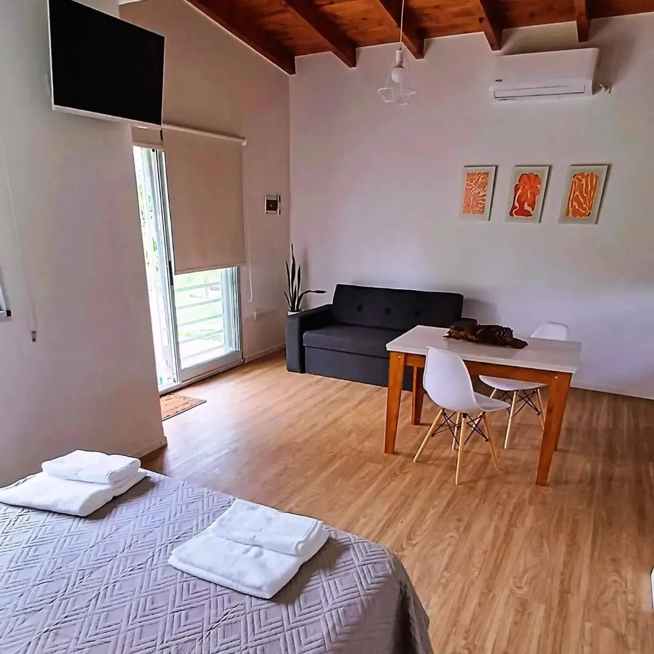 Interior de un loft con cama, living y comedor