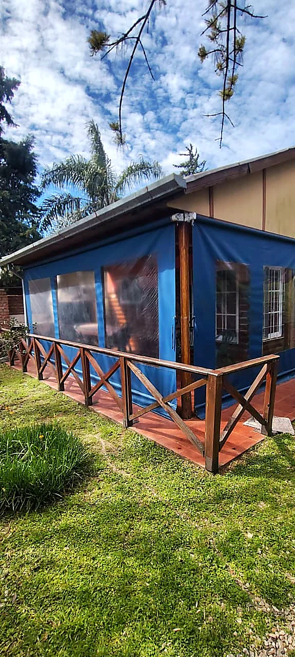 Galería cerrada de la cabaña, con baranda de madera