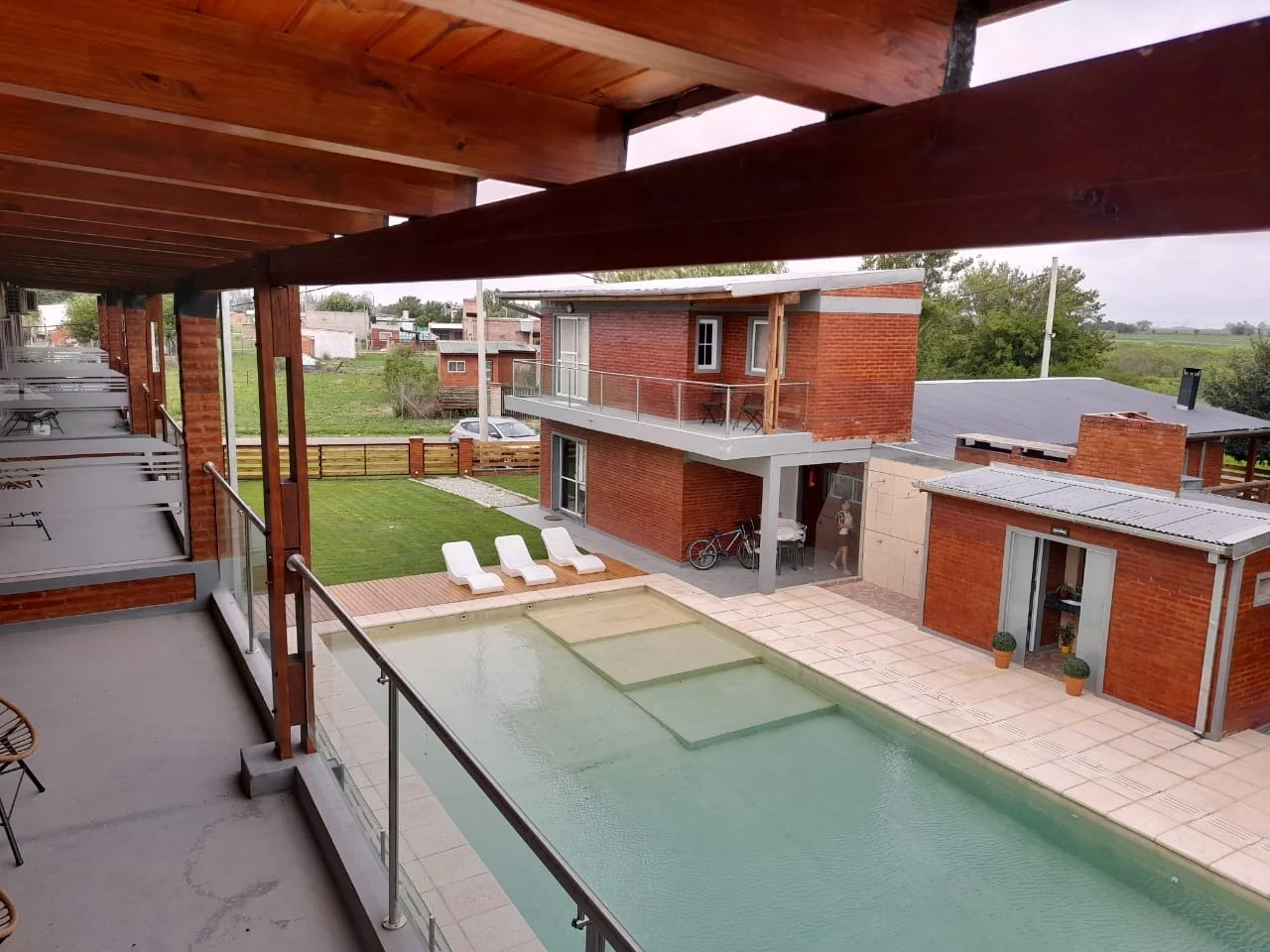 Vista de la pileta y el parque desde la galería de los apartamentos