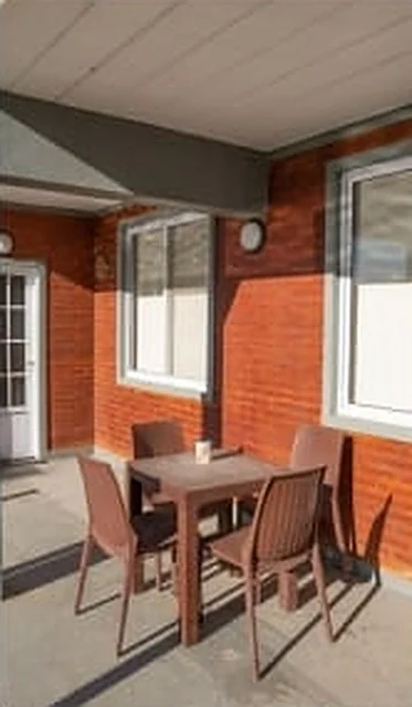 Galería con mesa frente a los apartamentos