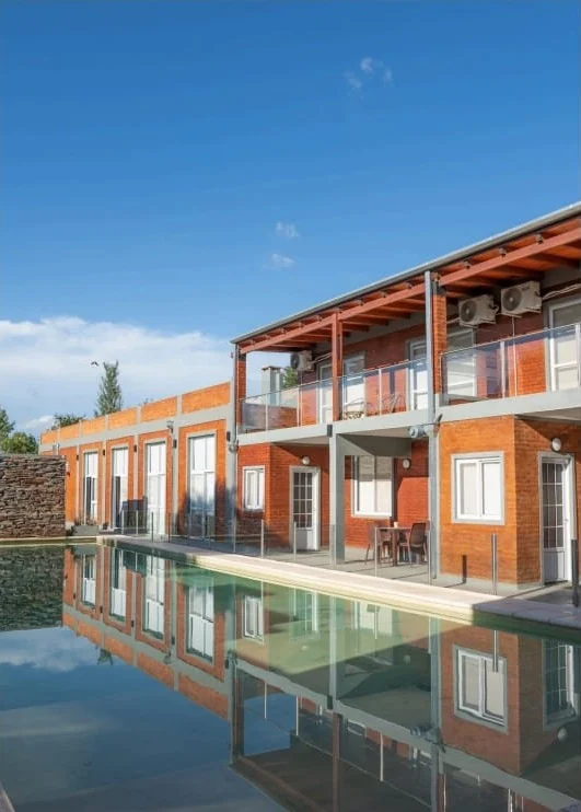 Los apartamentos de ladrillo reflejados en la pileta