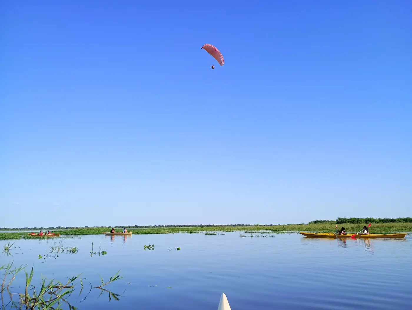 Paratrike volando sobre el río con kayaks abajo