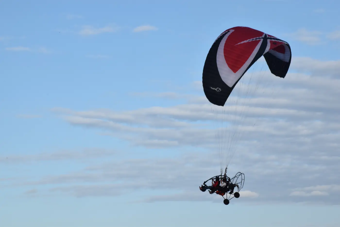 Paratrike en vuelo con el ala roja y negra
